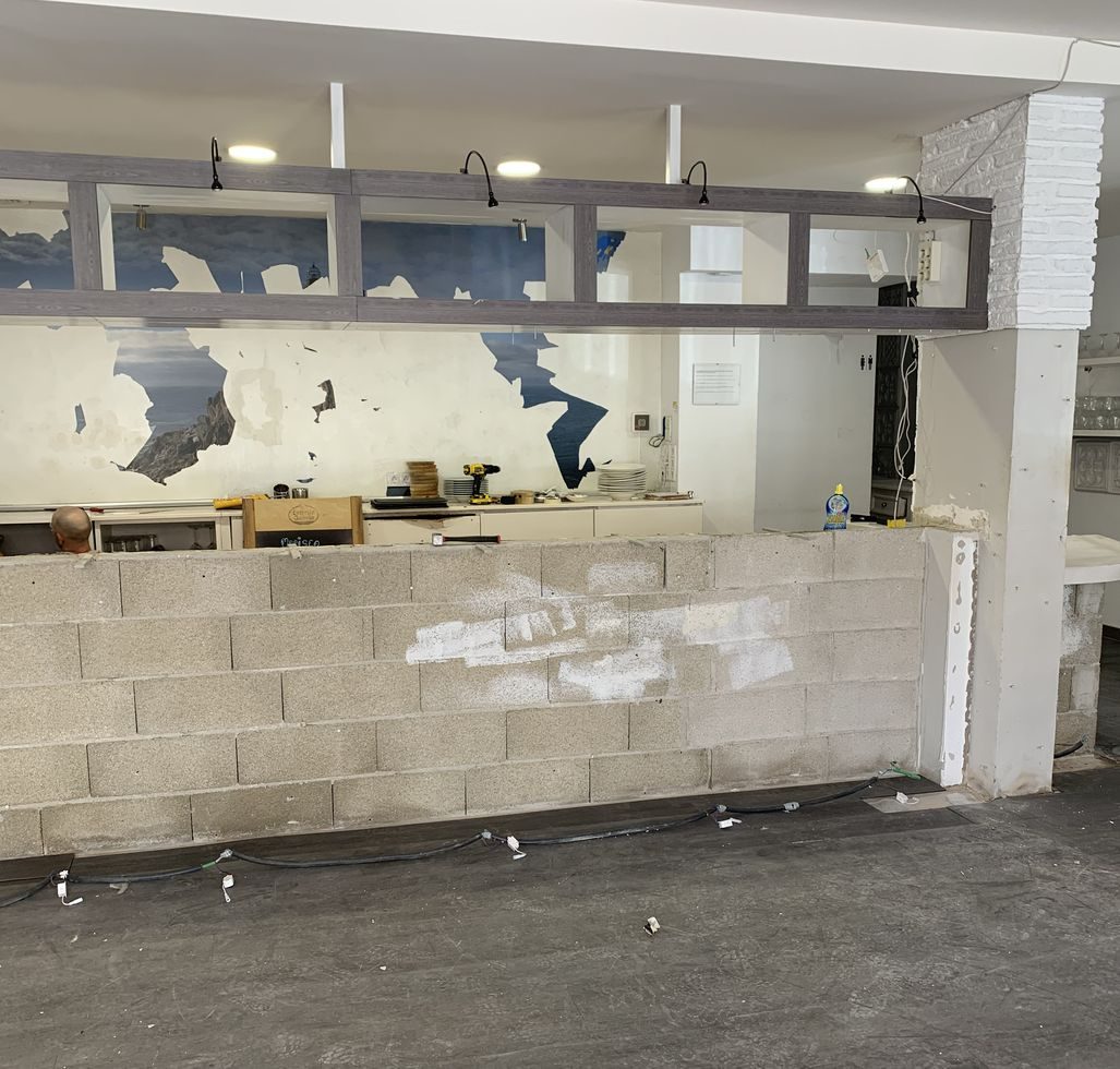 The unit before work began: bare blockwork and a stripped-out bar